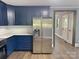 Kitchen featuring stainless steel fridge, dark blue cabinets, and an opening through to the hallway at 201 Barnes Ln, Stony Point, NC 28678