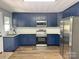 Modern kitchen boasts sleek stainless steel appliances, dark blue cabinets, and elegant countertops at 201 Barnes Ln, Stony Point, NC 28678