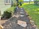 Landscaped walkway featuring decorative rocks, mulch, and lush green plants, enhancing curb appeal at 201 Barnes Ln, Stony Point, NC 28678