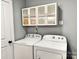 Laundry room with washer, dryer, and white cabinets with glass doors for storage at 201 Barnes Ln, Stony Point, NC 28678