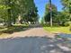 Street view featuring mature trees lining both sides, with houses visible in the distance at 201 Barnes Ln, Stony Point, NC 28678