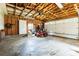 Spacious garage with a concrete floor, exposed wood beams, and a roll-up garage door at 2028 Old Latter Rd, Newton, NC 28658