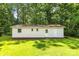 A small, white outbuilding with a brown trim in a backyard with mature trees at 2028 Old Latter Rd, Newton, NC 28658