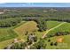 Wide aerial shot of a large farm with fields, forest, and a charming home with a pool at 2145 Jack Wilson Rd, Shelby, NC 28150