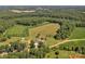 Aerial view of farmland and surrounding wooded areas with the home's pool visible at 2145 Jack Wilson Rd, Shelby, NC 28150