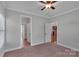 Bright bedroom featuring neutral walls, carpet flooring, ceiling fan, and a glimpse into adjacent rooms at 2145 Jack Wilson Rd, Shelby, NC 28150