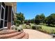 Beautiful backyard with lush landscaping, brick steps and patio overlooking the golf course at 406 Spyglass Hill Pl, Salisbury, NC 28144