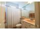 Bathroom with light wood vanity and full mirror featuring a shower with a white curtain at 406 Spyglass Hill Pl, Salisbury, NC 28144