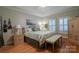 This bedroom features a large bed, hardwood floors, and bright natural light from the window at 406 Spyglass Hill Pl, Salisbury, NC 28144
