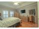 This bedroom offers hardwood floors and ample storage with wooden dressers and a large TV at 406 Spyglass Hill Pl, Salisbury, NC 28144