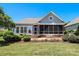 Back exterior view of home showing patio, screened porch, beautiful landscaping, and golf course at 406 Spyglass Hill Pl, Salisbury, NC 28144