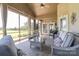 Enclosed sunroom featuring comfortable wicker furniture with scenic views of the golf course at 406 Spyglass Hill Pl, Salisbury, NC 28144