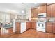 An open kitchen with wood cabinets, white appliances, and an island-style counter at 407 Knops Nob Rd, Mooresville, NC 28115