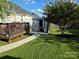 Grassy backyard showcasing a covered patio space with outdoor furniture and a dining space on the deck at 4204 Canipe Dr, Charlotte, NC 28269