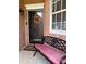 A bench with a wreath hangs on the front door, next to a window with grids at 4204 Canipe Dr, Charlotte, NC 28269