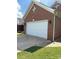 A two-car garage with a white door and brick facade, side view at 4204 Canipe Dr, Charlotte, NC 28269