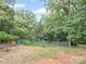 The backyard features a chainlink fence, mature trees and a storage shed at 430 Edgegreen Dr, Charlotte, NC 28217