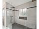 Modern bathroom featuring a glass-enclosed shower, contemporary tiling, and a decorative niche at 430 Edgegreen Dr, Charlotte, NC 28217