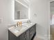 Bathroom vanity featuring marble countertop, double sinks, and gold fixtures at 430 Edgegreen Dr, Charlotte, NC 28217