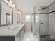 Elegant bathroom featuring double vanities, stylish lighting, and a glass-enclosed shower at 430 Edgegreen Dr, Charlotte, NC 28217