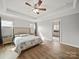 Bright bedroom with hardwood floors, a ceiling fan, recessed lighting, and a large bed next to an open bathroom at 430 Edgegreen Dr, Charlotte, NC 28217