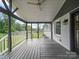 A covered porch with gray painted floors, white railings, and peaceful outdoor view at 430 Edgegreen Dr, Charlotte, NC 28217