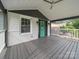 A spacious covered porch with white railings, painted gray floors, and an elegant front door at 430 Edgegreen Dr, Charlotte, NC 28217