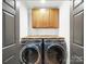 Laundry room featuring washer and dryer under butcher block counters and cabinets at 430 Edgegreen Dr, Charlotte, NC 28217