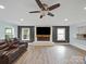 Bright living room with hardwood floors, recessed lighting, and a fireplace with a wall-mounted television at 430 Edgegreen Dr, Charlotte, NC 28217