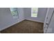 A bedroom with neutral carpet, white walls, white trim, and natural light at 4501 E Highway 27 Hwy, Iron Station, NC 28080