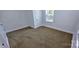 Bright bedroom featuring neutral carpet, white walls, and a window view at 4501 E Highway 27 Hwy, Iron Station, NC 28080