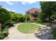 Professionally landscaped backyard with a circular lawn, lush greenery, and a view of the home's exterior at 460 E 33Rd St, Charlotte, NC 28205