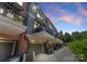 Townhome complex featuring private balconies, brick accents, and modern architectural details under a vibrant sunset at 460 E 33Rd St, Charlotte, NC 28205