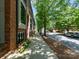 Sidewalk view of brick townhomes with well-maintained landscaping and tree-lined streets at 460 E 33Rd St, Charlotte, NC 28205