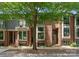 Attractive townhome featuring brick accents, large windows, and a well-manicured front yard with a mature tree at 460 E 33Rd St, Charlotte, NC 28205