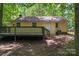 Yellow home featuring a wood deck in a wooded backyard at 5534 Great Wagon Rd, Charlotte, NC 28215