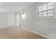 A bedroom with white walls, wood-look floors, window, and door leading to backyard at 5534 Great Wagon Rd, Charlotte, NC 28215