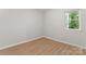 Light-filled bedroom with wood-look floors and a window providing views of lush greenery at 5534 Great Wagon Rd, Charlotte, NC 28215