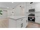 This open-concept kitchen features white cabinets, an island, and stainless steel appliances at 5534 Great Wagon Rd, Charlotte, NC 28215
