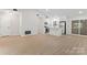 Open-concept living room with modern kitchen, white cabinets, stainless steel appliances, and wood-look floors at 5534 Great Wagon Rd, Charlotte, NC 28215