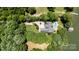 A gorgeous aerial view showcases the property, with a pool, boat dock, manicured lawn and lush trees at 584 Williamson Rd, Mooresville, NC 28117