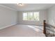 Bright bonus room featuring neutral carpet, trim, and large windows for natural light at 584 Williamson Rd, Mooresville, NC 28117