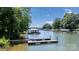 Picturesque waterfront view featuring a dock and boathouse surrounded by clear water and other homes along the shoreline at 584 Williamson Rd, Mooresville, NC 28117