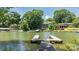 A serene lakefront view featuring a wooden dock with stunning houses on the shore and blue skies at 584 Williamson Rd, Mooresville, NC 28117