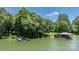 Beautiful waterfront view featuring docks and a boathouse enveloped by trees and a tranquil lake at 584 Williamson Rd, Mooresville, NC 28117