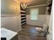 Charming bathroom features a classic chandelier, stylish flooring, and modern wainscoting at 6616 Love Mill Rd, Monroe, NC 28110