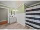 Charming bathroom with beadboard wainscoting, chandelier, and black and white striped shower curtain at 6616 Love Mill Rd, Monroe, NC 28110