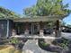 Inviting covered porch with stone supports, seating, and well-manicured landscaping at 6616 Love Mill Rd, Monroe, NC 28110