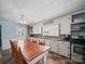 Bright kitchen featuring ample white cabinetry, brick accents, modern appliances, and a dining area at 6616 Love Mill Rd, Monroe, NC 28110