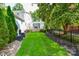 Manicured backyard with a black fence, lush greenery, and a small porch at 711 Yadkin St, Albemarle, NC 28001